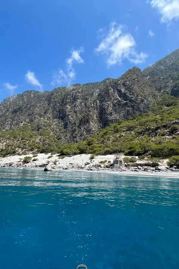Calm turquoise bay and traditional seaside architecture lining the coast of Agios Pavlos.